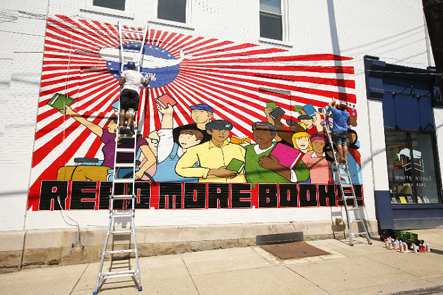 Brian Gonnella (right) and Jerome Charles work on alterations to White Whale Bookstore's mural on Fri., June 25, 2021. - CP PHOTO: JARED WICKERHAM