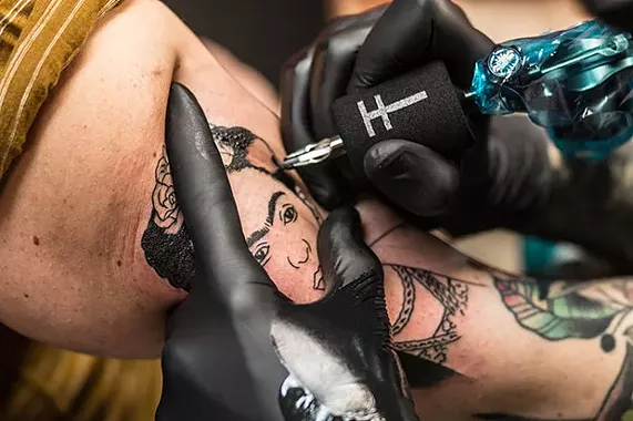 Marcus Nati from Stay Gold Tattoo gives Angela Skinner a Frida Kahlo civil-rights tattoo. - CP PHOTO BY KATEY LADIKA