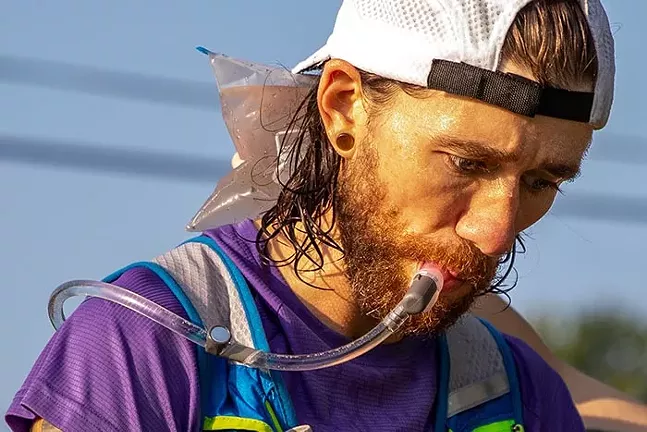 Greg Brunner drinks water and gets cooled off at aid station two at mile 10.3 of the Baker Trail Ultra Challenge. - CP PHOTO: KAYCEE ORWIG