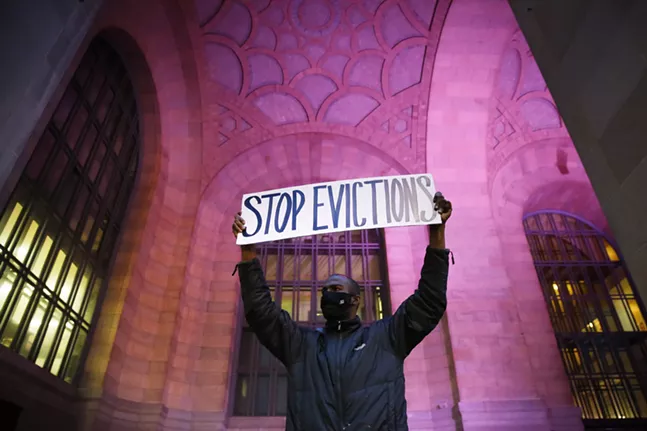 Lou, a Pittsburgh resident facing eviction in February, holds up a sign during a rally outside of the Pittsburgh's City-County Building in February. - CP PHOTO: JARED WICKERHAM