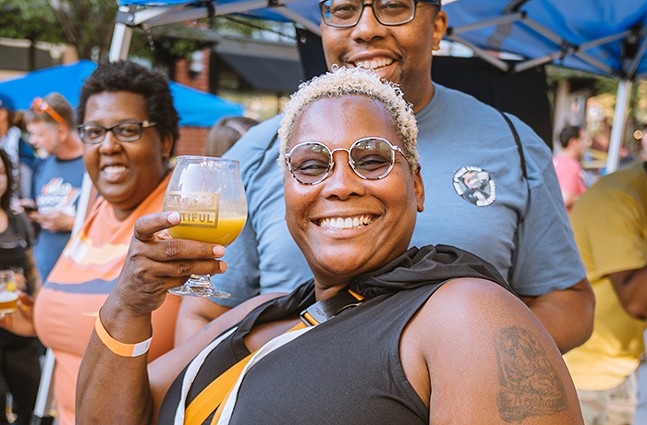 A group of Black beer drinkers smile at Barrel and Flow Fest