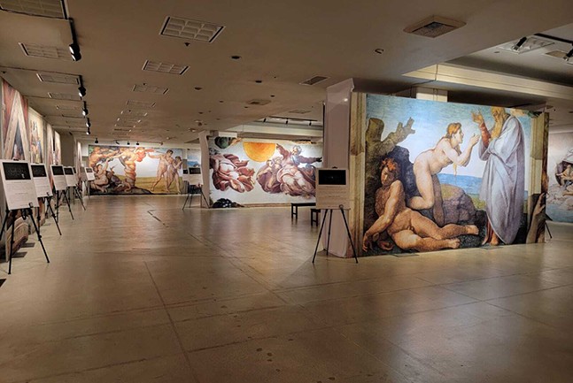 A series of Michelangelo reproductions are set up in an otherwise unadorned event space.