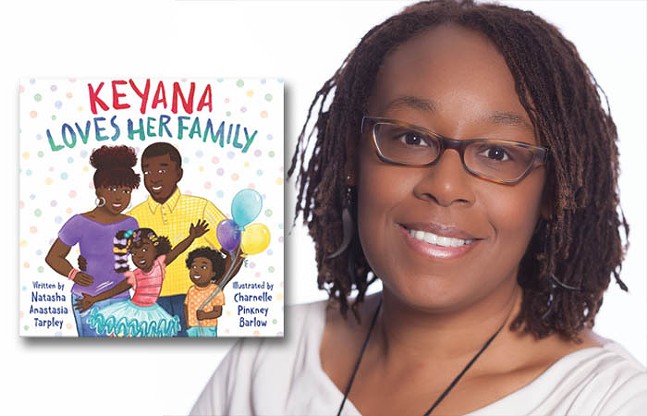 A Black woman in glasses and a white top smiles for the camera next to an insert of a children's book titled Keyana Loves Her Family