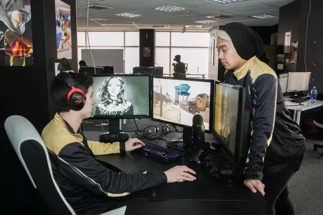 Rob Lee observes Jace Patras playing PUBG at the Pittsburgh Knights’ Hazelwood office. - CP PHOTO BY JOHN COLOMBO