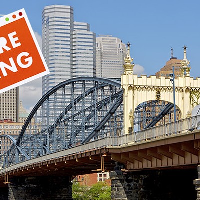 A bridge goes over a river in front of the Downtown Pittsburgh skyline. A sign that says "we're hiring" is Photoshopped on top of the photo