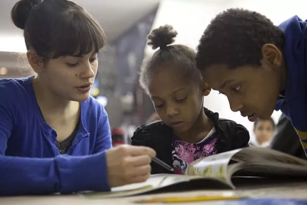 Volunteer Lintelman works with siblings Faith and Tyrek. - PHOTO BY HEATHER MULL