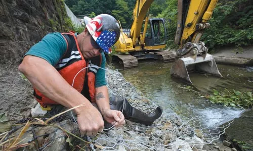 Workers install gabion baskets to prevent erosion along Girty's Run. - HEATHER MULL