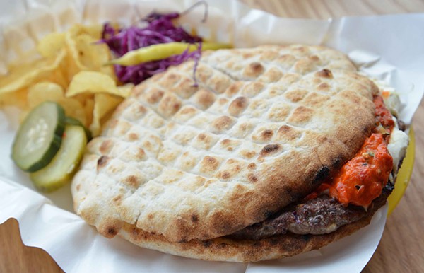 The pljeskavica or "balkan burger" is grilled and placed on a flatbread with cheese, kajmak and somun. - TOM HELLAUER