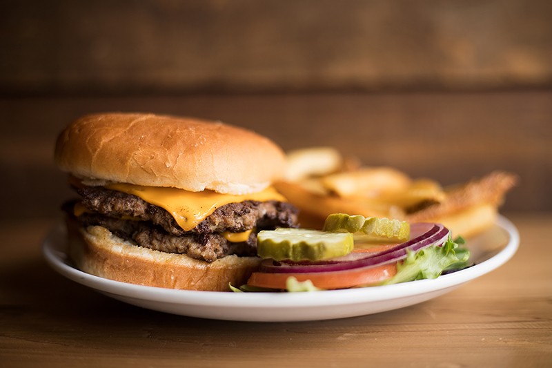 The double cheeseburger is topped with lettuce, tomato, pickle and onion and served with fries. - MABEL SUEN