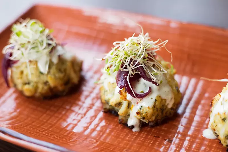 The crab cakes are made with a shockingly generous amount of crab and served with lemon aioli and pickled red onion. - MABEL SUEN