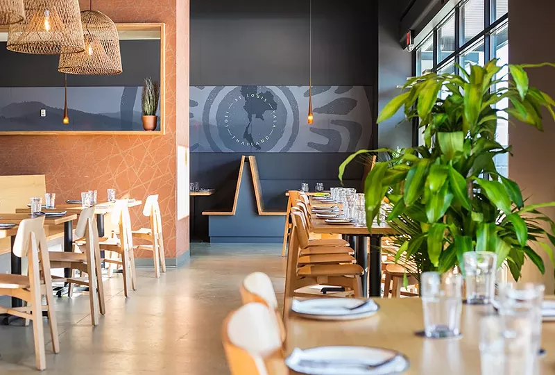The vibe inside Chao Baan is sophisticated and features blonde wood tables and banquettes, gray-blue walls and striking basket-like chandeliers that cast a warm glow over the dining room. - MABEL SUEN