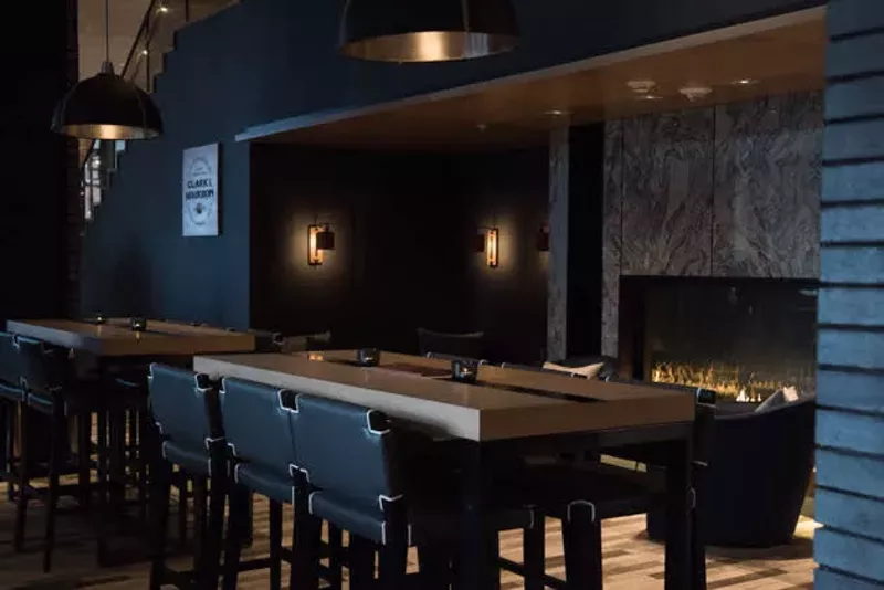 Communal and lounge seating at Bar Bourbon as well as a view of its gorgeous fireplace. - TRENTON ALMGREN-DAVIS