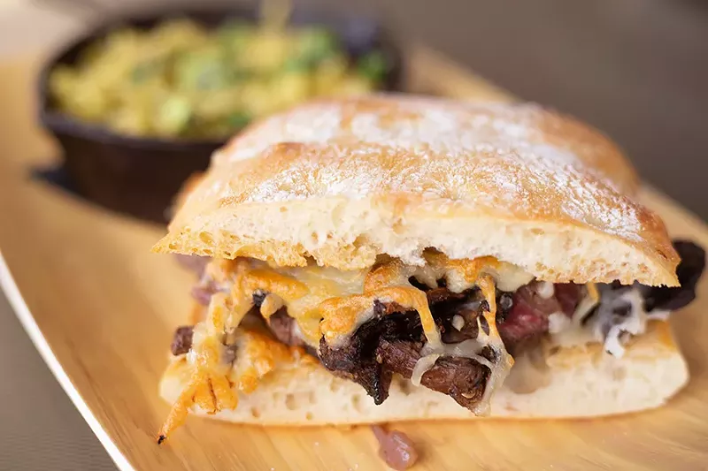 The steak sandwich stacks beef tenderloin, caramelized onions, roasted red peppers, goat cheese, gouda and mozzarella between two slices of multigrain bread. - MABEL SUEN