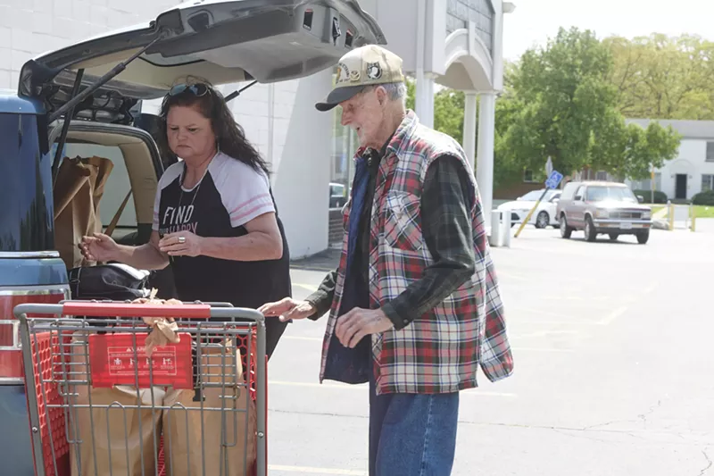 Caregiver Denise Phelps helps her 85-year-old uncle, William Speck, with groceries from Feed My People on April 24 in Lemay. - MARY BUTKUS