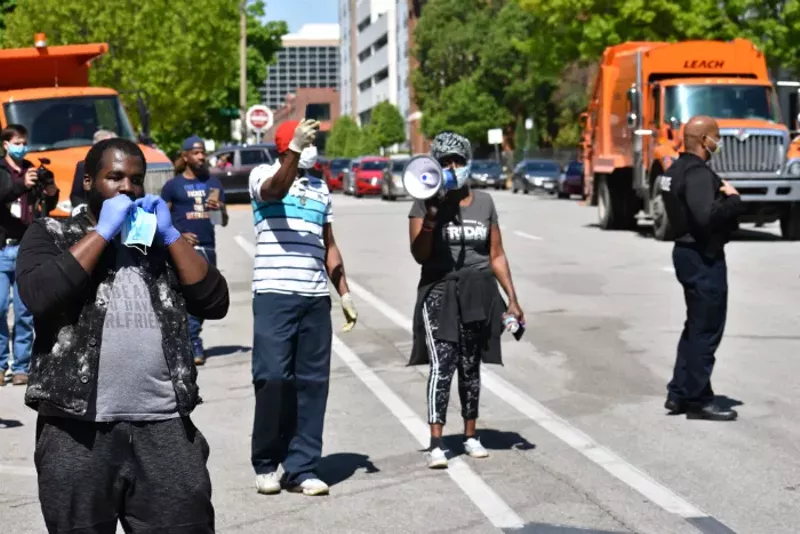 After rebuffing an attempt to clear the camps on Friday, people cheer the exit of police and garbage trucks. - DOYLE MURPHY