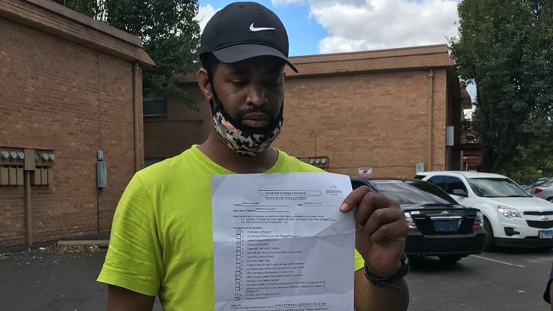 Terrell Porter is holding the letter his wife Janica Washington received from Sansone Group, the owner of Southwest Crossing apartments. The letter informed the couple they had violated tenant rules because of what she said in an RFT story published in August. - MIKE FITZGERALD