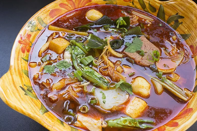 Mala soup is a build-your-own menu item, pictured here with spicy beef broth, vegetables, tofu, fish balls, ham and beef tripe. - PHOTO BY MABEL SUEN