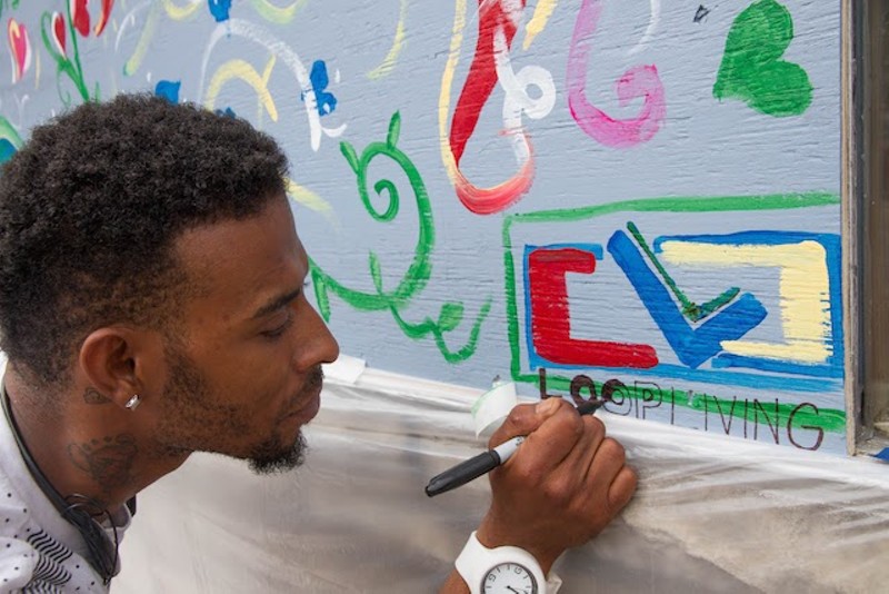 Jomar Jackson paints at Loop Living. - COURTESY OF PAINTING FOR PEACE IN FERGUSON, A CHILDREN'S BOOK