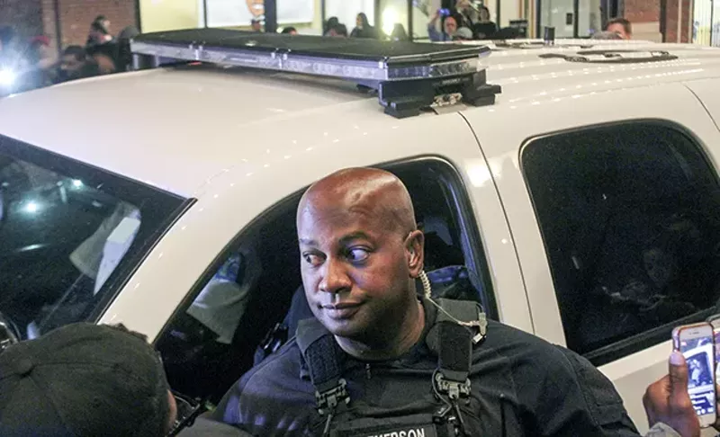 Sgt. Randy Jemerson tries to calm protesters mobbing the car of his colleague. - DOYLE MURPHY