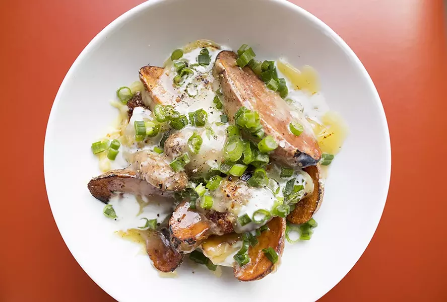"New Town Skins" are smothered in raclette cheese, spicy pork, green onion and housemade sour cream. - MABEL SUEN