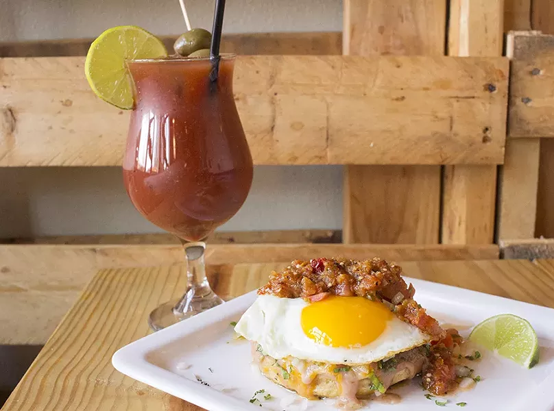 The carnitas breakfast sope comes with refried beans, cheese and a fried egg. - PHOTO BY MABEL SUEN