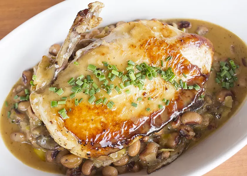 A cast iron-seared chicken breast is served over shiitake mushroom and leek-braised beans with lemon-garlic pan jus. - PHOTO BY MABEL SUEN