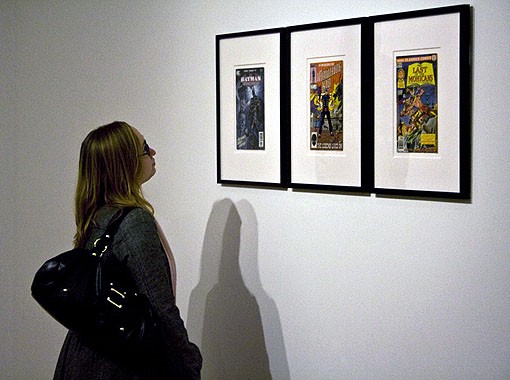 Another onlooker looks at the comic books upon entering the gallery. - PHOTO: EMILY GOOD