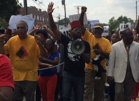 Baruti, left, marches in Ferguson on August 11. - MITCH RYALS