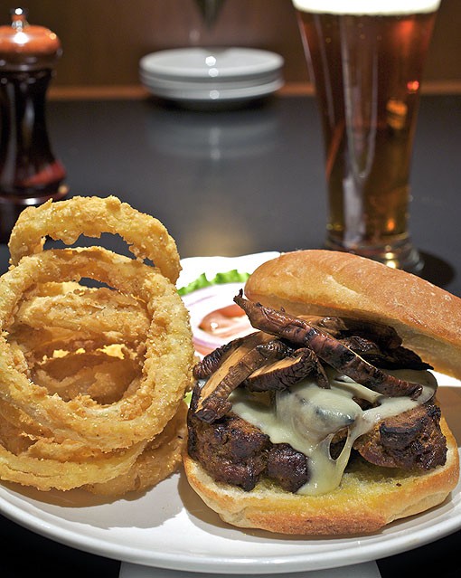 The grilled meatloaf sandwich is served with wild mushrooms, Swiss cheese and chipotle ranch dressing on a ciabatta roll. It is shown here with onion rings. See more photos from inside Hanley's in this slideshow. - PHOTO: JENNIFER SILVERBERG