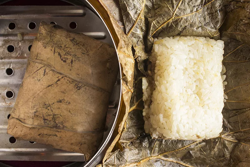Sticky rice in lotus leaf: Sweet rice, Chinese sausage, pork, egg and shiitake mushrooms wrapped in a large tea leaf and steamed. - PHOTO BY MABEL SUEN