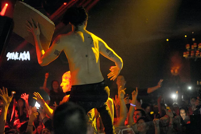 Aoki tosses cake into the crowd. - PHOTO BY KELLY GLUECK