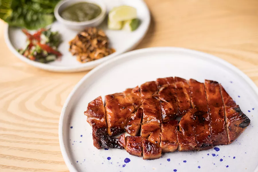 The pork steak is served with leek salad, salsa fresca and butter lettuce cups. - MABEL SUEN