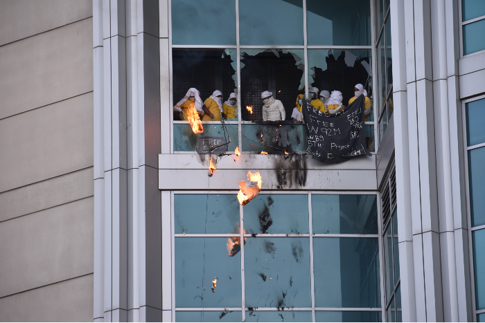 Inmates drop flaming debris from the windows. - DOYLE MURPHY