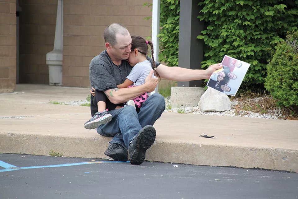 Days after an immigration judge ordered Dow's deportation in 2014, Justin Boyer comforts the couple's young daughter outside a Troy, Missouri jail. - RENEE BRONAUGH/PARK HILLS DAILY JOURNAL