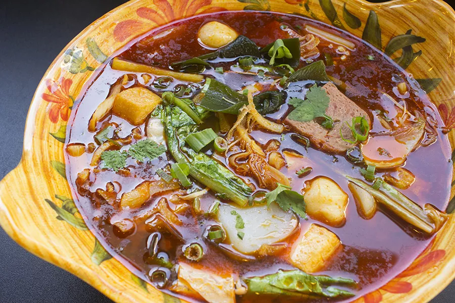 Mala soup is a build-your-own menu item, pictured here with spicy beef broth, vegetables, tofu, fish balls, ham and beef tripe. - PHOTO BY MABEL SUEN