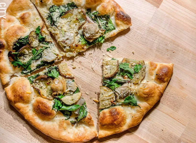 A pizza with little-neck clams, Swiss chard, roasted potatoes, and shaved garlic from Aunt Rosie's. - PHOTO BY MARK CHAMBERLIN