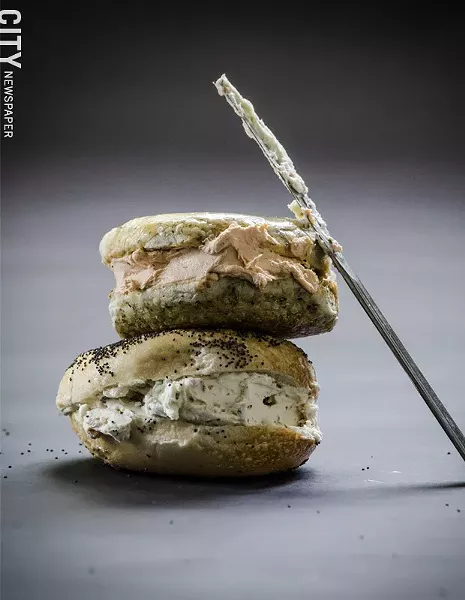 Bagel Land's toppings are so thick they can be considered sandwiches. Pictured here is the spinach bagel with tomato-pesto cream cheese and a poppyseed bagel with bacon-scallion cream cheese. - PHOTO BY MARK CHAMBERLIN