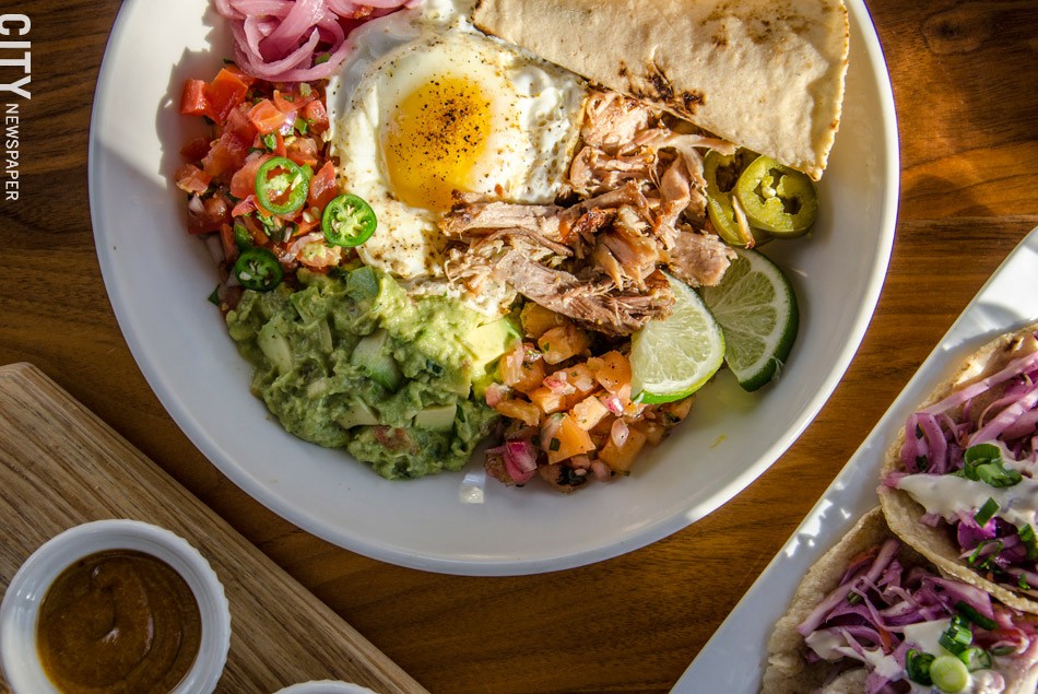 carnitas plate: roasted pork, tortillas, beans, salsa, gremolata, queso crema, guacamole, pickled vegetables, and a fried egg. - PHOTO BY MARK CHAMBERLIN