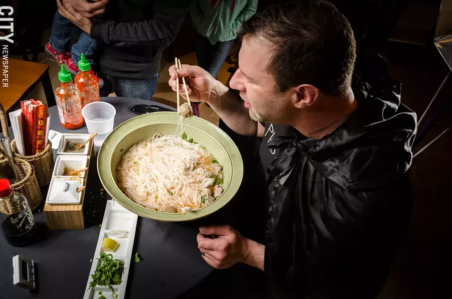 Greg Davis attempts to eat a seven-pound bowl of Pho at The Soup Spoon in Victor. - PHOTO BY MARK CHAMBERLIN