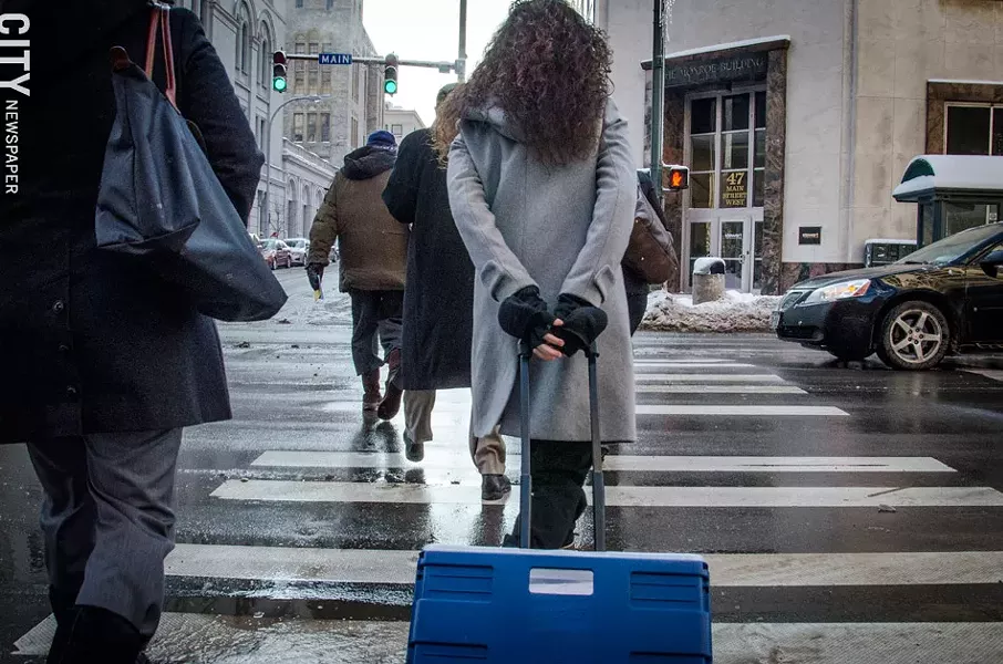 Public Defender Fabienne Santacroce walks to court, pulling a cart full of case files. - PHOTO BY MARK CHAMBERLIN