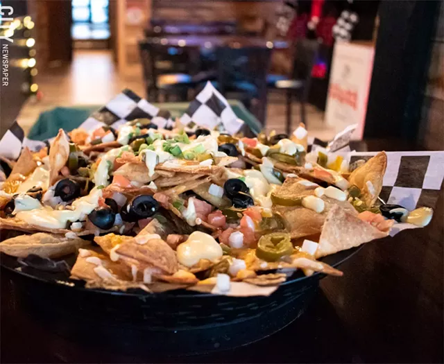 The loaded nachos were the best our writer has had in the city: tortillas buried in tomatoes, olives, cheddar jalapeños, spicy queso, and well-seasoned chicken. - PHOTO BY JACOB WALSH