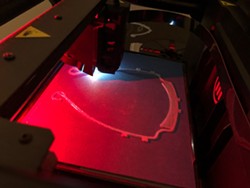 A 3D printer, on load to Coty Pastene from the Webster school district, prints the headband for a face shield. - PHOTO PROVIDED