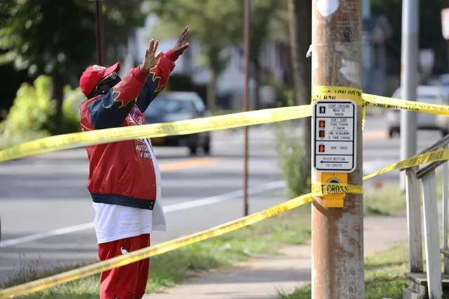 Bishop Patrick McNair prays on the corner of Pennsylvania Avenue and North Goodman Street after a mass shooting erupted during a house party early Saturday on Pennsylvania Avenue. - PHOTO BY MAX SCHULTE