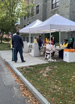 Staff register people for free COVID-19 testing and flu vaccinations at Aenon Baptist Church on Genesee Street. - CREDIT WXXI NEWS