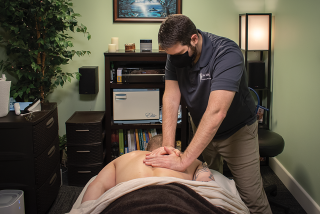 Shawn Belles of Pain Relief Massage & Wellness in Penfield works on a client. - PHOTO BY RYAN WILLIAMSON