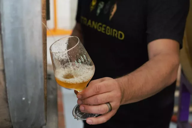 Eric Salazar pours a glass of a Belgian Golden Ale straight from the barrel. - PHOTO BY GINO FANELLI