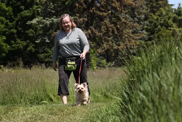 Ingrid Bock walks Diesel on a Penfield trail. - PHOTO BY MAX SCHULTE