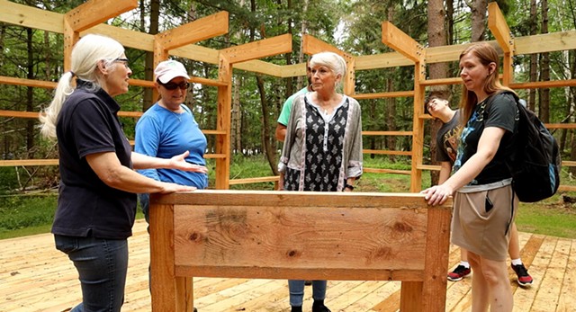 Loren Penman shows off a sensory table to Anne Quivey, Catherine Abida, Pat Strobel, Ali Abida and his mom, Catherine Abida at the Autism Nature Trail at Letchworth State Park. - PHOTO BY MAX SCHULTE