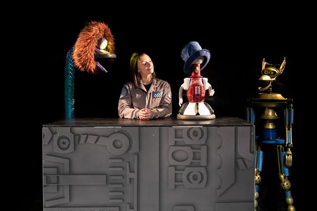 Emily Marsh appears on stage alongside (left to right) GPC (Yvonne Freese), Tom Servo (Conor McGiffin) and Crow T. Robot (Nate Begle).  - PHOTO BY BRANDI MORRIS