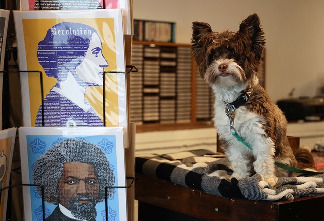 Dellaria's dog, Indy, is often by the artist's side in his new store. - PHOTO BY MAX SCHULTE / WXXI NEWS